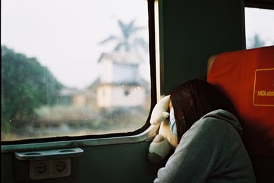 女人在灰色连帽衫,睡在火车面罩
